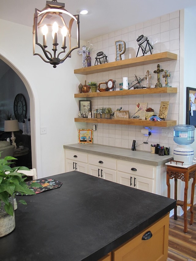 1208 Leslie Ln, Lufkin, TX 75901 - dining area featuring arched walkways, wood finished floors, and a chandelier