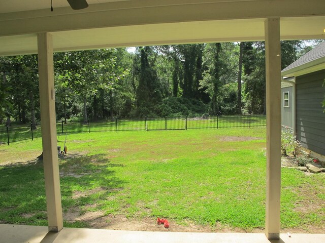 1208 Leslie Ln, Lufkin, TX 75901 - fenced backyard featuring ceiling fan and view of wooded area
