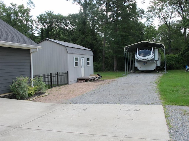 1208 Leslie Ln, Lufkin, TX 75901 - garage with a detached carport, gravel driveway, and view of wooded area