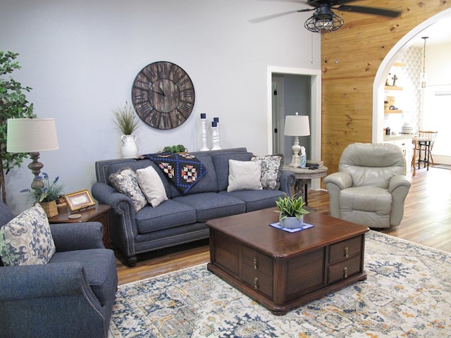 1208 Leslie Ln, Lufkin, TX 75901 - living room with light wood-style flooring, wooden walls, a ceiling fan, and arched walkways