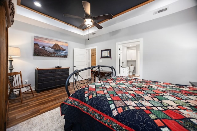 1208 Leslie Ln, Lufkin, TX 75901 - bedroom with wood finished floors, a raised ceiling, connected bathroom, and a ceiling fan