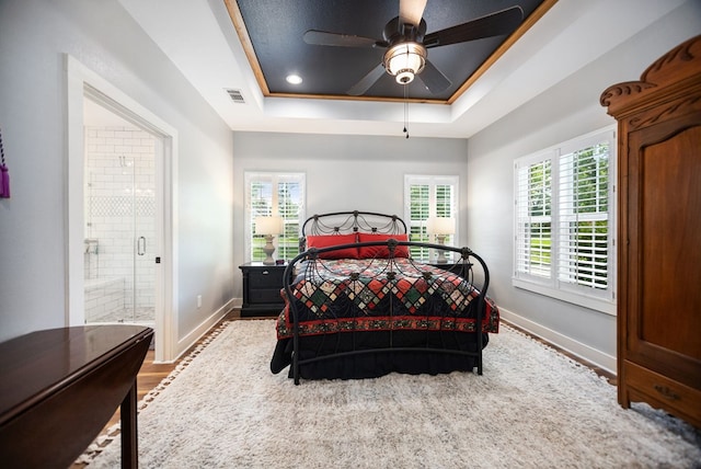 1208 Leslie Ln, Lufkin, TX 75901 - bedroom with a raised ceiling, ensuite bathroom, wood finished floors, and a ceiling fan