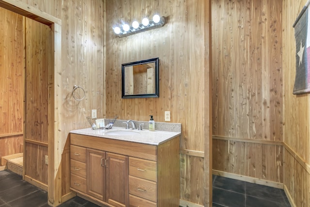 bathroom with tile patterned flooring, vanity, and wood walls