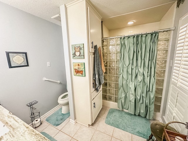 full bath featuring tile patterned floors, toilet, a textured ceiling, and tiled shower
