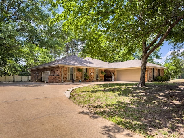 ranch-style home featuring concrete driveway, an attached garage, fence, and brick siding