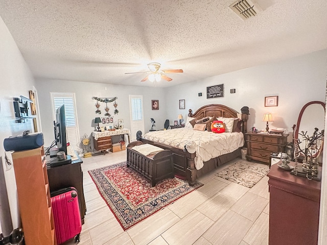 bedroom with visible vents, a textured ceiling, and ceiling fan