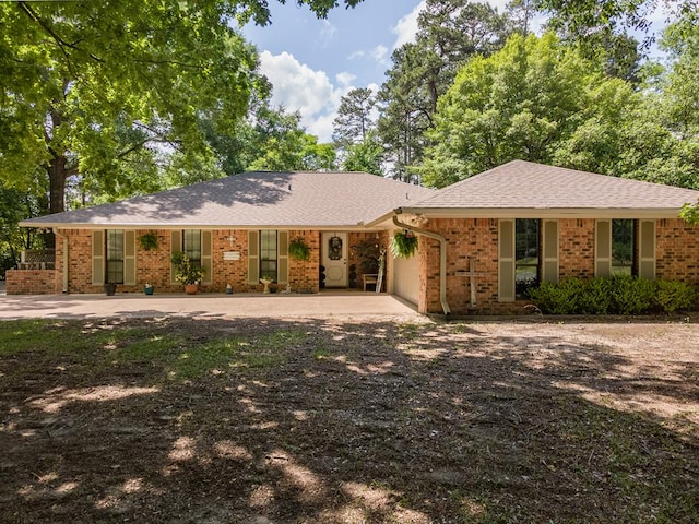 ranch-style house featuring an attached garage, driveway, and brick siding