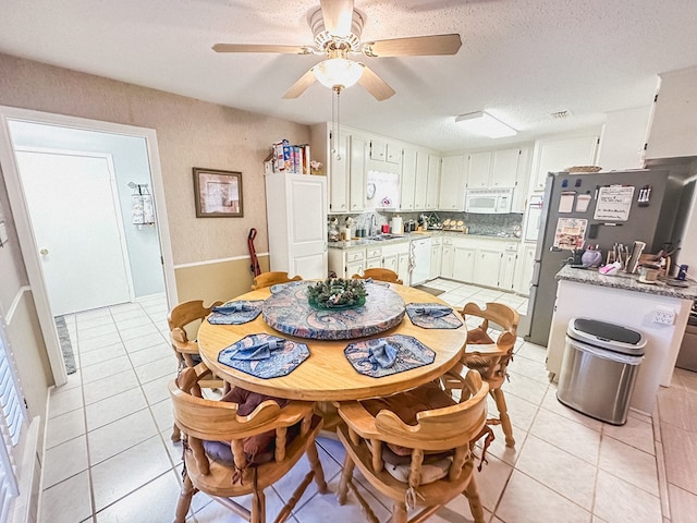 dining room with a ceiling fan, a textured ceiling, and light tile patterned floors