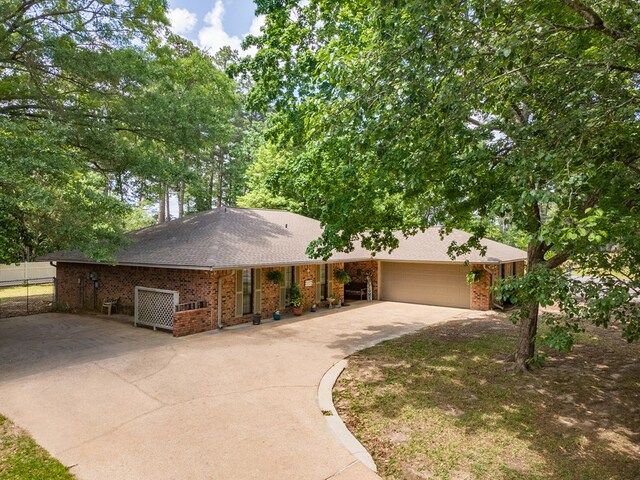 ranch-style house with brick siding, driveway, a shingled roof, and a garage