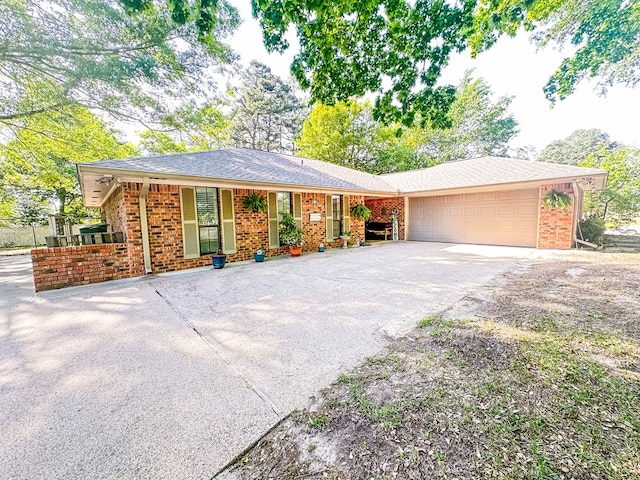 ranch-style home with a porch, driveway, brick siding, and a garage