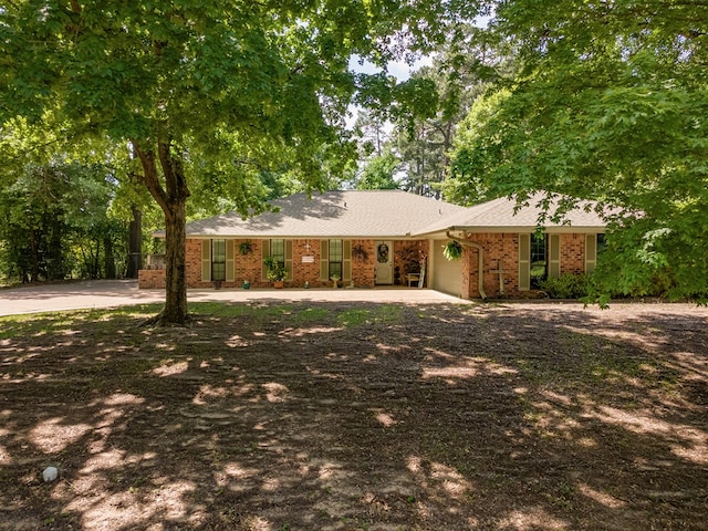single story home featuring brick siding, an attached garage, and driveway