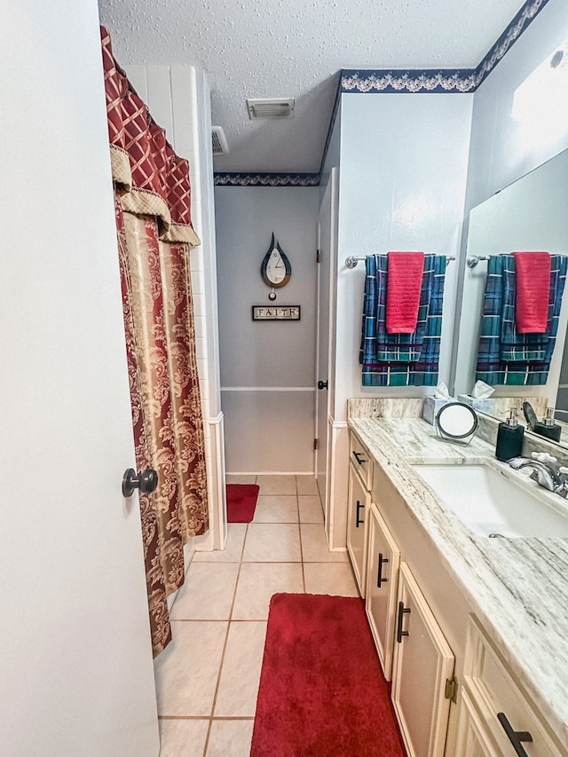 bathroom with vanity, tile patterned floors, visible vents, and a textured ceiling