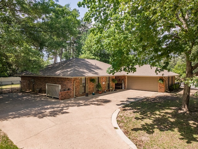 ranch-style home with fence, a shingled roof, concrete driveway, brick siding, and a garage