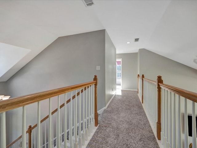 hallway with light colored carpet and vaulted ceiling