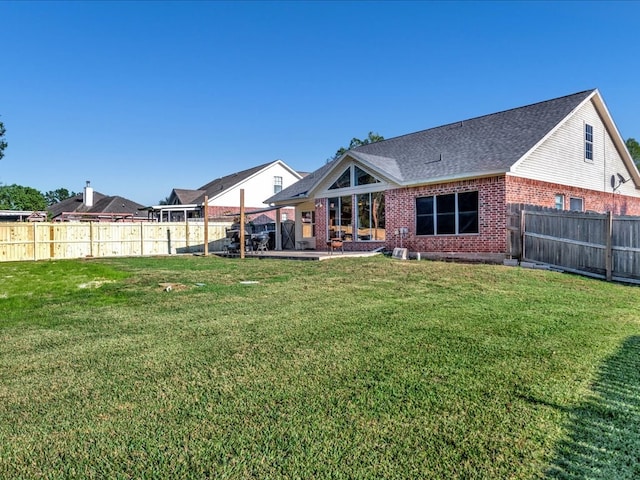 rear view of house with a yard and a patio