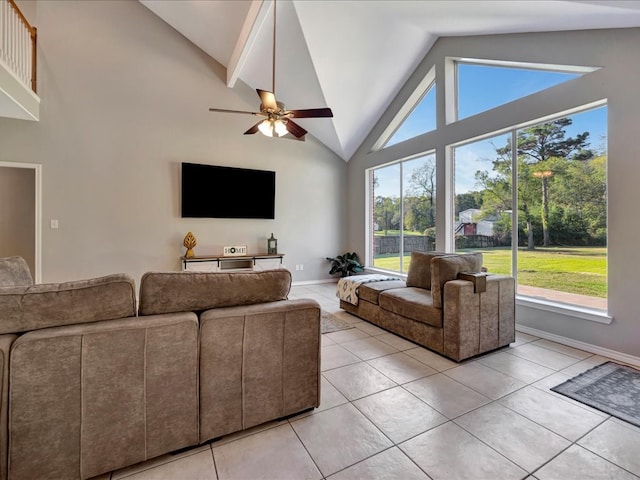 tiled living room with ceiling fan, a healthy amount of sunlight, and high vaulted ceiling