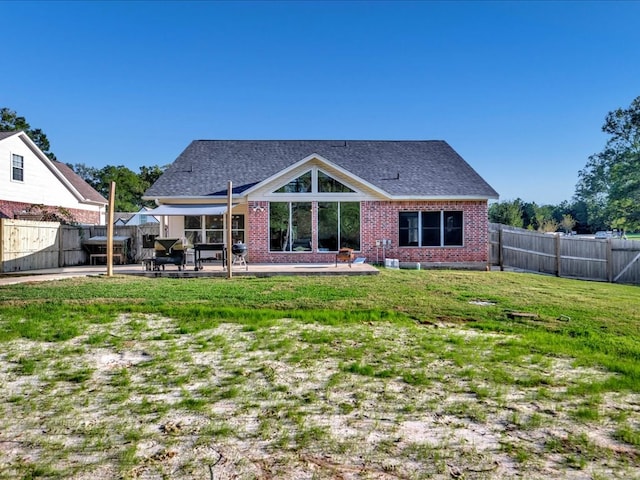 rear view of house featuring a lawn and a patio area