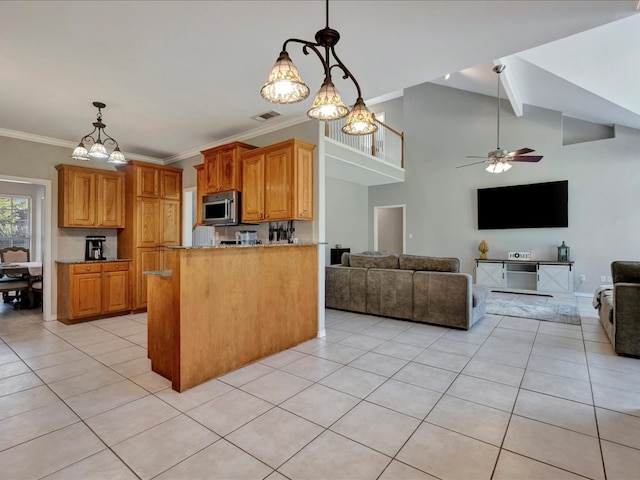 kitchen featuring ceiling fan with notable chandelier, light tile patterned flooring, kitchen peninsula, and ornamental molding