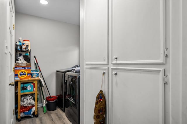 laundry area featuring laundry area, washing machine and clothes dryer, and wood finished floors