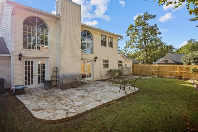 rear view of house with french doors, a patio, central AC, and a lawn