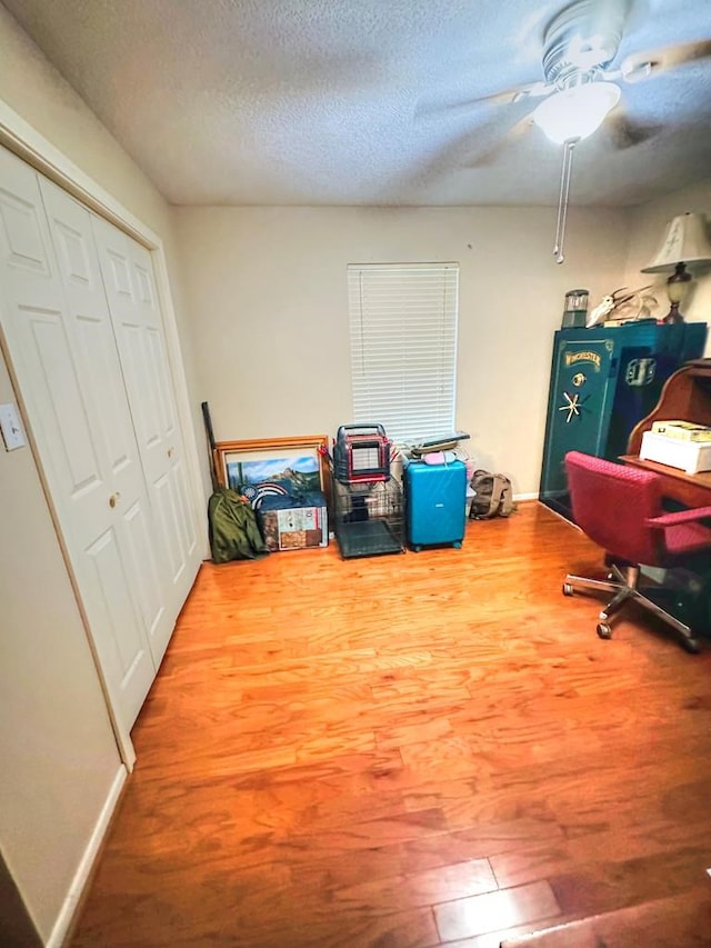 interior space featuring ceiling fan, a textured ceiling, and hardwood / wood-style flooring