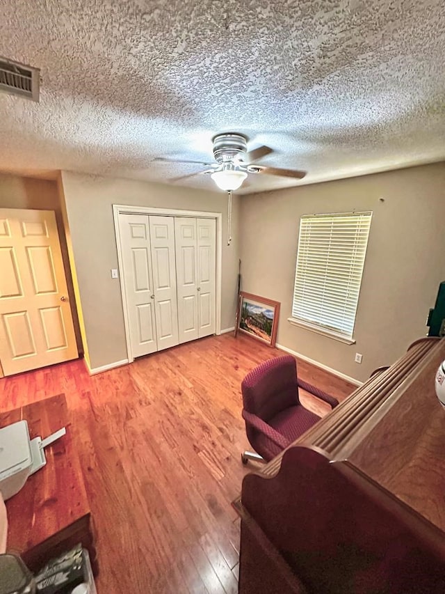 living area featuring wood-type flooring and a textured ceiling