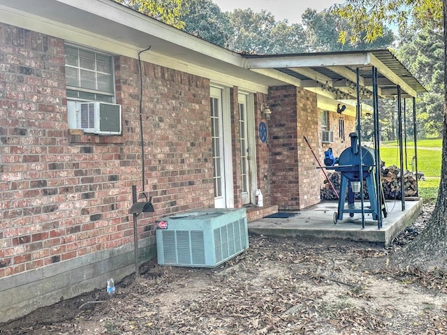 view of patio featuring a grill, cooling unit, and central AC unit