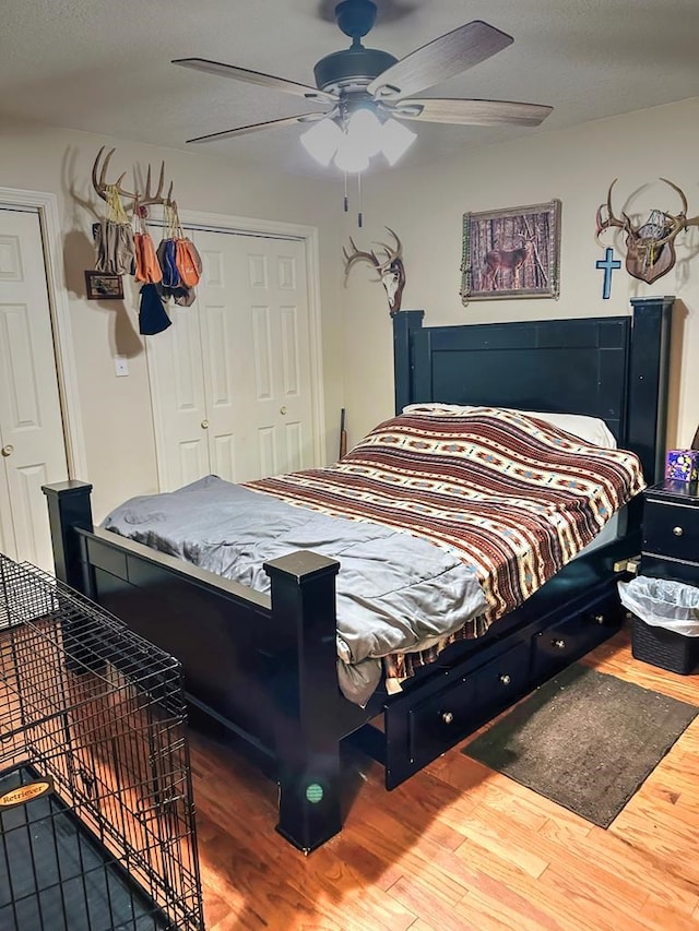 bedroom with wood-type flooring, a closet, and ceiling fan