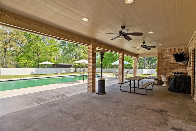 view of patio / terrace featuring ceiling fan and a fenced in pool