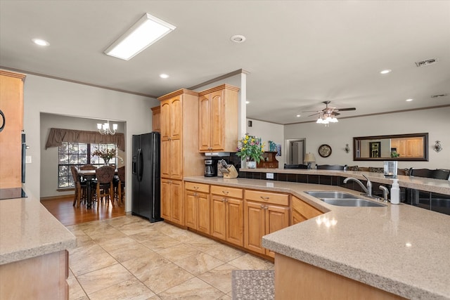 kitchen with light brown cabinetry, ornamental molding, ceiling fan with notable chandelier, sink, and black appliances