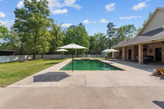 view of pool with a patio and a lawn