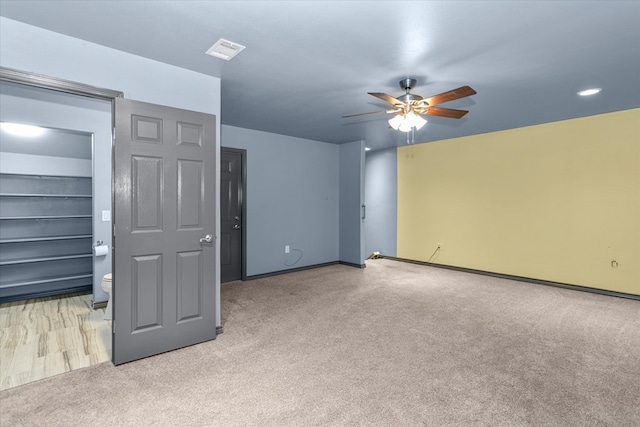 unfurnished bedroom with light colored carpet, ceiling fan, and ensuite bathroom