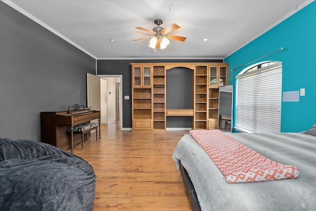 bedroom with ceiling fan, wood-type flooring, and ornamental molding