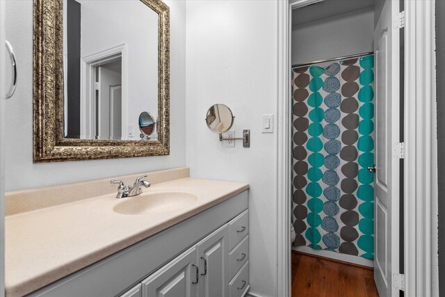 bathroom with walk in shower, vanity, and hardwood / wood-style flooring