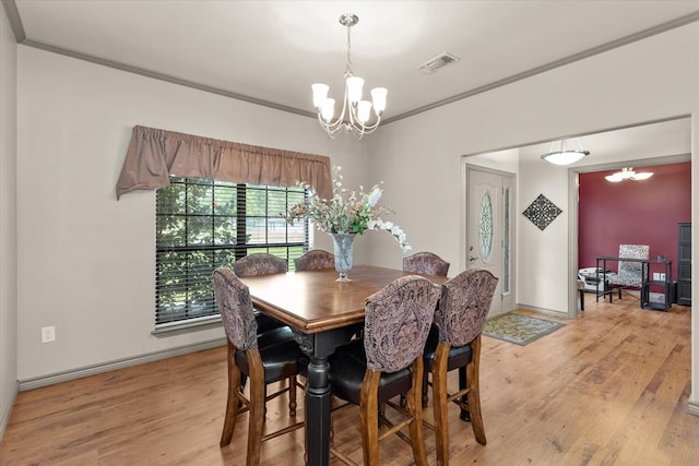 dining room featuring an inviting chandelier, wood-type flooring, and ornamental molding