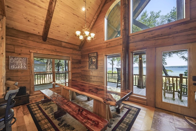 dining room with a water view, high vaulted ceiling, and a wealth of natural light