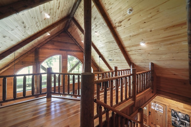 additional living space with vaulted ceiling with beams, wooden walls, hardwood / wood-style floors, and wooden ceiling