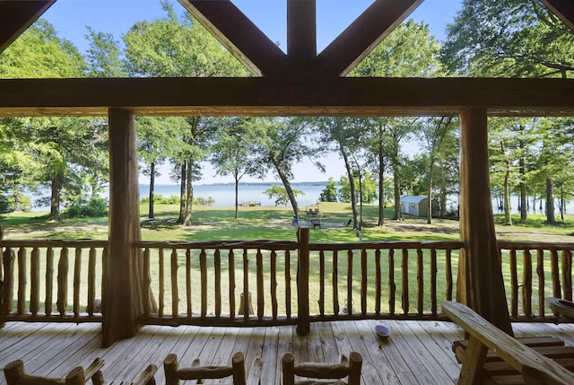 wooden terrace featuring a water view and a yard