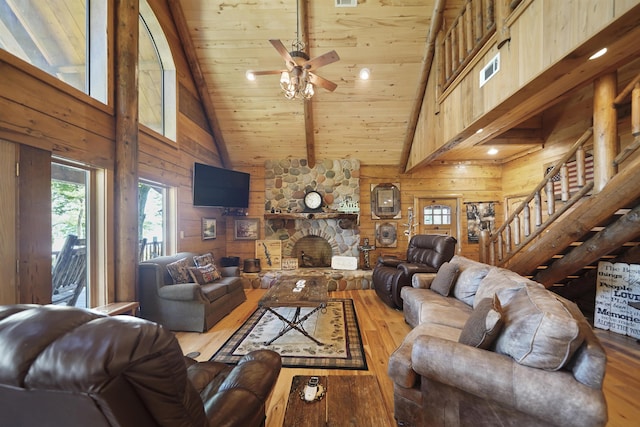 living room featuring ceiling fan, wood walls, light wood-type flooring, and high vaulted ceiling