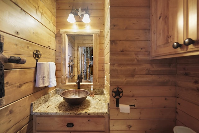 bathroom with vanity and wooden walls