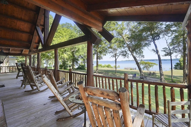 deck with a yard and a water view