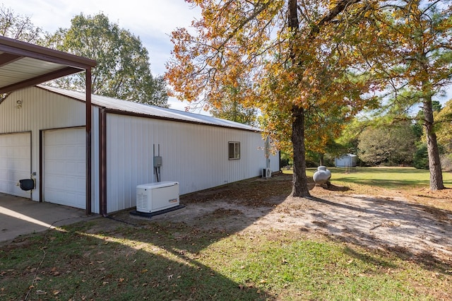 view of property exterior with a lawn, an outbuilding, a garage, and metal roof