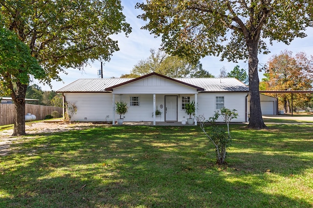 ranch-style house featuring fence, covered porch, a front yard, and metal roof