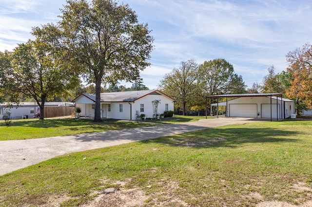 single story home featuring a front lawn, a detached garage, concrete driveway, fence, and an outdoor structure