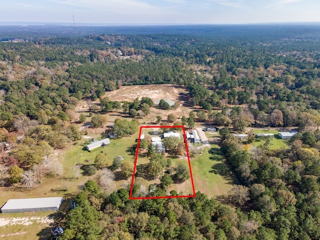 birds eye view of property featuring a forest view
