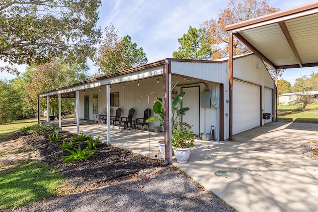 rear view of property with a patio area and a detached garage