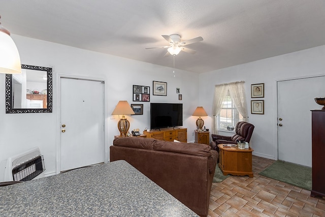 living area featuring a ceiling fan and heating unit