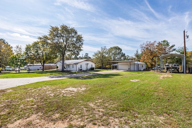 view of yard with a garage, a detached carport, an outdoor structure, and driveway