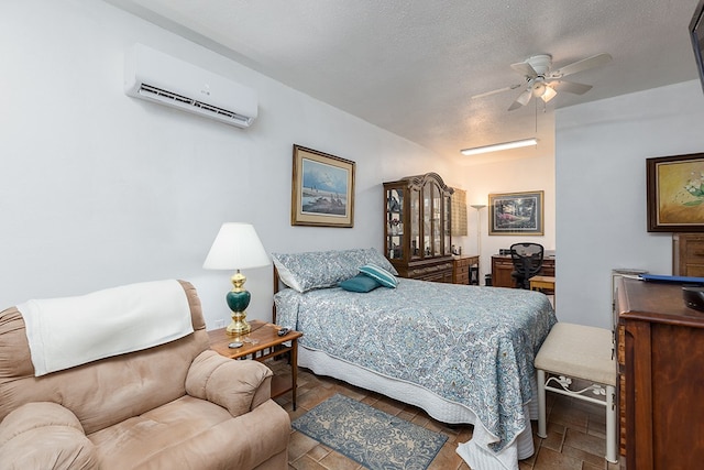 bedroom featuring a ceiling fan, a wall mounted AC, and a textured ceiling