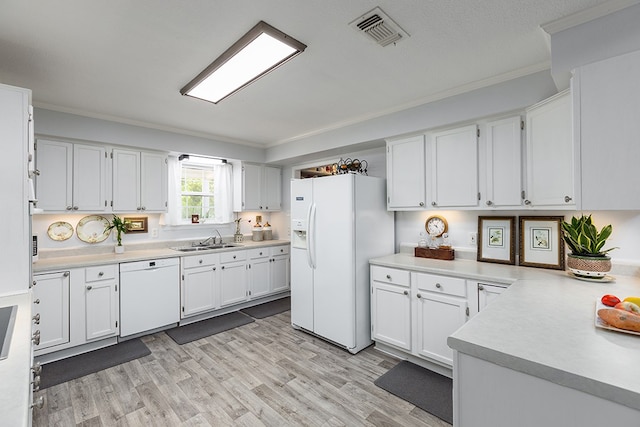 kitchen with ornamental molding, visible vents, a sink, and white appliances
